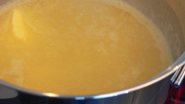 Butter in a steel bowl is almost completely melted - closeup