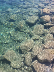 Maltese beach underwater viev of crystall clear turquoise water. Comino island stone beach with amazing wave and sunlight. Mediterranean seashore.