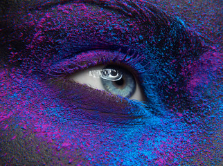 Macro and close-up creative make-up theme: Beautiful female eye with dry paint dust pigment on...