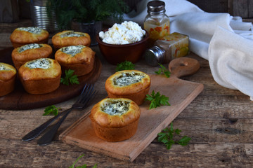 Savory feta cheese muffins with spinach and dill on wooden background. Healthy food concept with copy space for text.