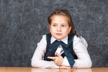 Portrait of happy little schoolchild on background of backboard in school