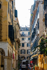 Fototapeta premium Narrow streets of Corfu island, Greece. Old and ramshackle buildings on sides and a working car