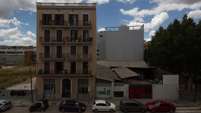 timelapse shot of an apartment building surround by derelict land in the poblenou district of barcelona