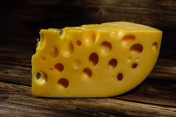 Piece of cheese on wooden table
