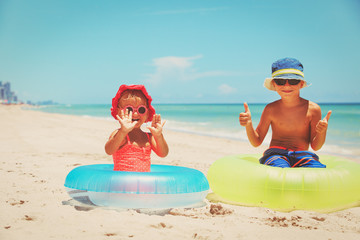 happy little boy and toddler girl play on beach