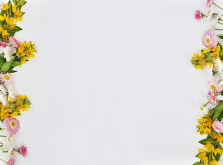Frame from flowers of daisies and yellow bells on a white background - obrazy, fototapety, plakaty