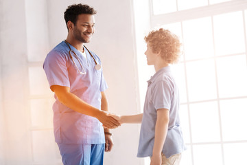 Obraz premium Kind teenager shaking hands with his doctor
