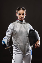 Young woman fencer in white fencing costume