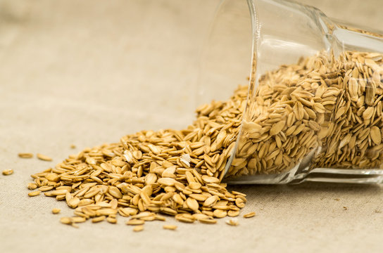oatmeat porridge flakes in a crystal glass on linen tablecloth