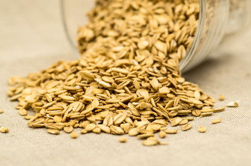 oatmeat porridge flakes in a crystal glass on linen tablecloth