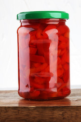 Jar with variety of pickled vegetables. Carrots, field garlic, c