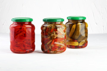 Jar with variety of pickled vegetables. Carrots, field garlic, cucumber in glas. Preserved food