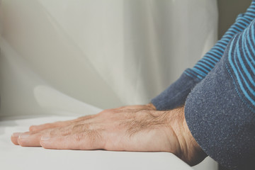 Naklejka premium Man leaning and puts his hands down on white cloth background