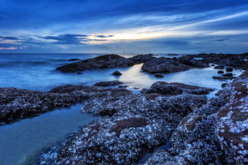 Obraz premium Rock over smooth foggy water level Slow Shutter Speed