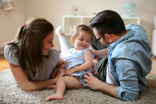 Happy family enjoy at home with their little baby.