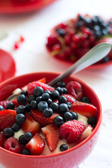 Healthy breakfast: cottage cheese with sour cream, strawberry, raspberry and blueberry, espresso, cherry cheesecake and plate of fresh ripe berries on white table cloth. Selective focus