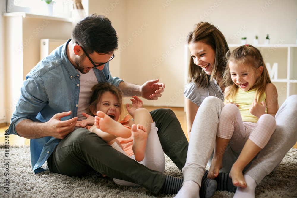 Wall mural Cheerful family with two child spending time at home.