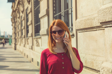 Cute attractive girl talking on her cellphone in the city.