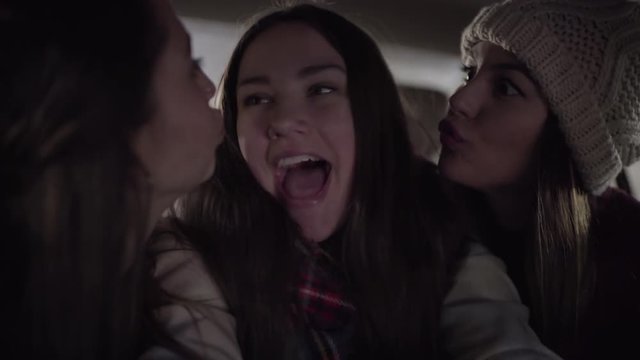 Closeup Of Happy Young Women Making Funny Faces And Cute Faces For Selfies In Backseat Of Moving Car 