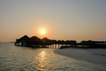 Sunset and water bungalows, abstract vacation background. Image has grain or blurry or noise and...