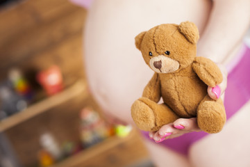 Teddy bear and Happy pregnant woman