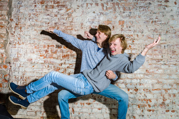 Two brothers posing in studio, teenage casual style