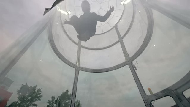 Professional skydiver flies in wind tunnel. Indoor skydiving tunnel