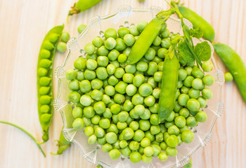 Green peas on a light oak background