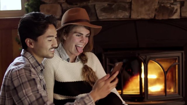 Closeup Of Cute Couple Posing For Fun Holiday Selfies By Fireplace