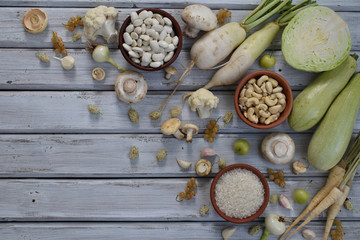 Obraz na płótnie Canvas White vegetables and fruits on a wooden background - currant, cauliflower, champignons, radish, parsley, mushrooms, garlic. Onion, cabbage, mulberry, rice, cashew, beans. Vegetarian food. Flat lay.