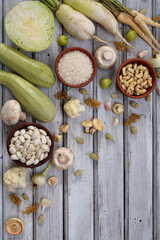 White vegetables and fruits on a wooden background - currant, cauliflower, champignons, radish, parsley, mushrooms, garlic. Onion, cabbage, mulberry, rice, cashew, beans. Vegetarian food. Flat lay.