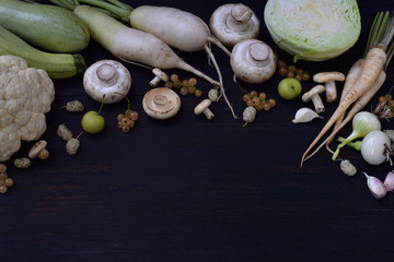 Obraz na płótnie Canvas White vegetables and fruits on a wooden background. Flat lay. Currant, cauliflower, champignons, radish, parsley, mushrooms, garlic. Onion, cabbage, mulberry