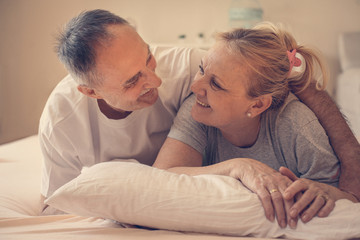 Older couple relaxing on bed.