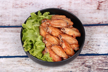 Deep fried chicken wings topped green oak.