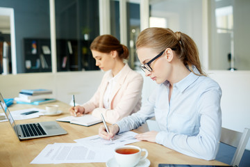Young analysts writing down their ideas