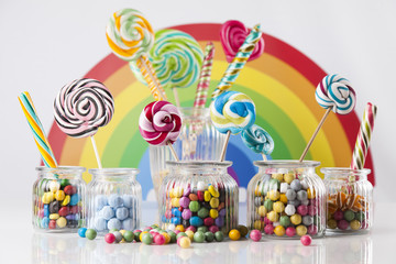 Fototapeta na wymiar Glass jars in Colorful candies,lollipops and gum balls