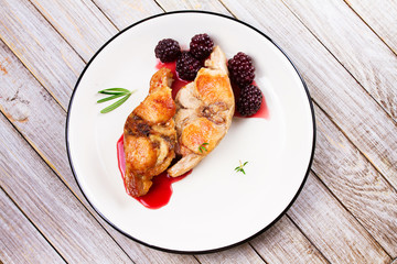 Rabbit in blackberry sauce with rosemary and thyme. View from above, top studio shot