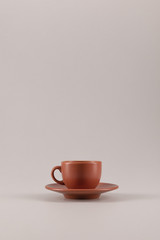 one ceramic coffee cup on saucer isolated on beige with copy space