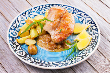 Rabbit with potatoes and lemon in cream sauce, garnished with tarragon