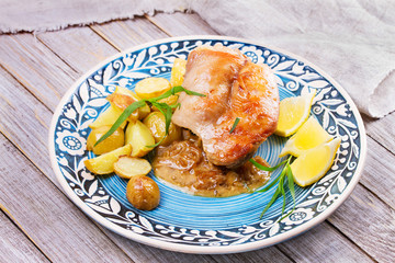 Rabbit with potatoes and lemon in cream sauce, garnished with tarragon