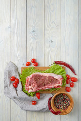 raw meat with ingredients on a wooden background