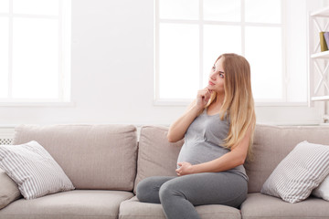 Pensive pregnant woman dreaming about child