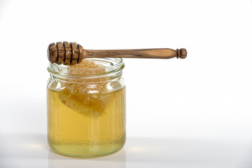 Honigglas mit Honigwabe und Abfüller