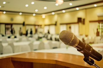 Microphone on podium with abstract blurred of conference hall or seminar room event background