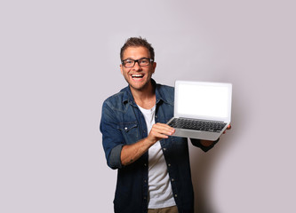 Young man in a denim shirt with a laptop