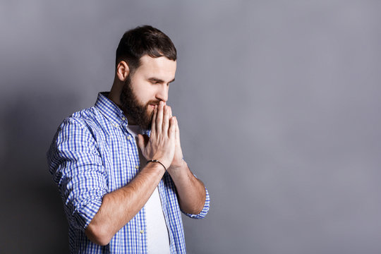 Portrait of hopeful bearded man praying,