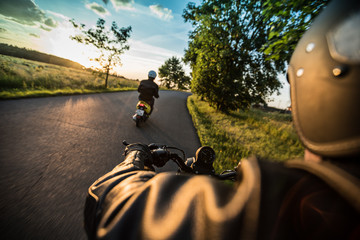 Fototapeta premium Man riding sportster motorcycle during sunset.