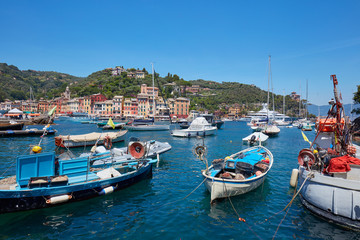 Fototapeta na wymiar Portofino typical beautiful village with colorful houses and small harbor with fishing boats in Italy