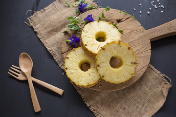 Obraz na płótnie Canvas Fresh Yellow Organic Pineapple cut into slices on wooden table
