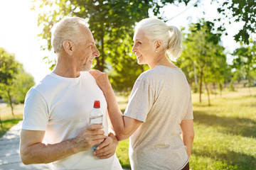 Cheerful aged couple resting after sport exercises